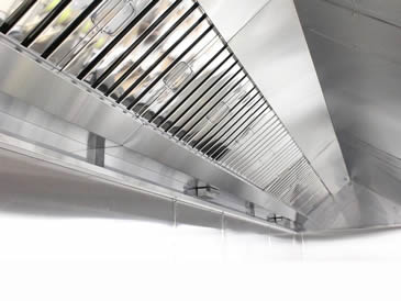 Several stainless steel baffle grease filters with fold flat handles are installed at commercial kitchen
